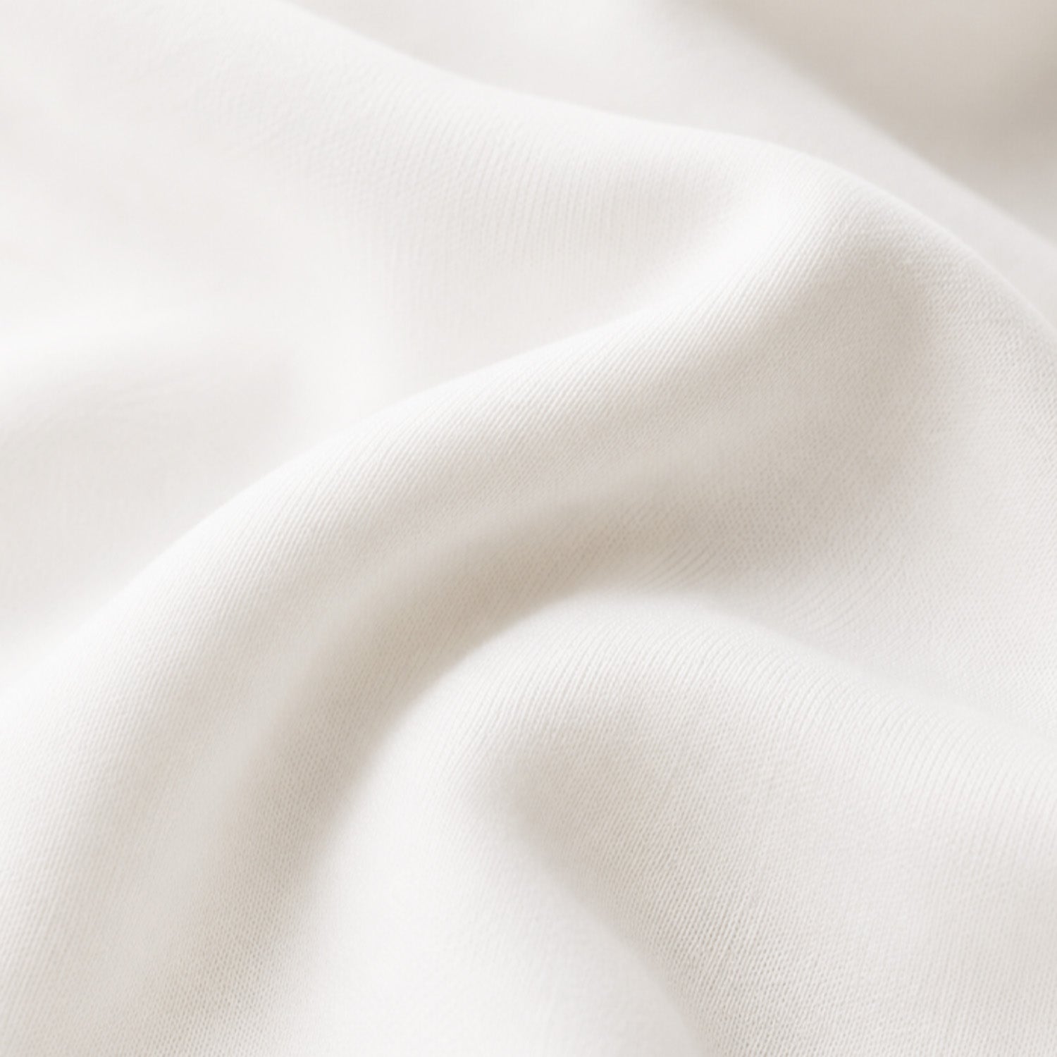 A close-up of draped off-white lyocell fabric with soft folds and a smooth texture.
