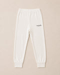 Off-white sweatpants with a small black 'suppla' logo on the left hip, displayed flat against a light beige background.