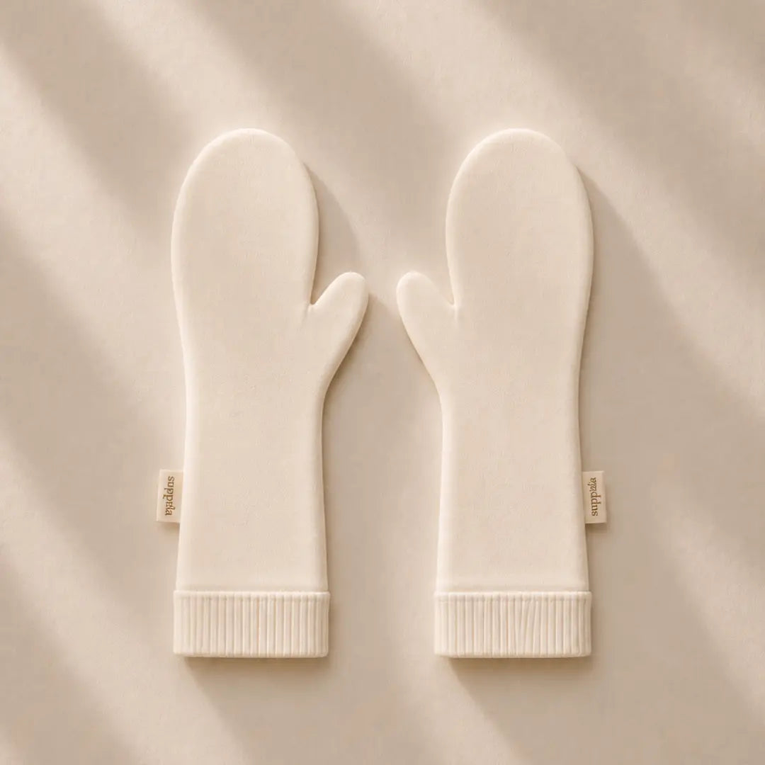 A pair of suppla scratch mittens with ribbed cuffs, laid flat on a  background with soft diagonal shadows. Small fabric tags on the wrists read 'suppla'